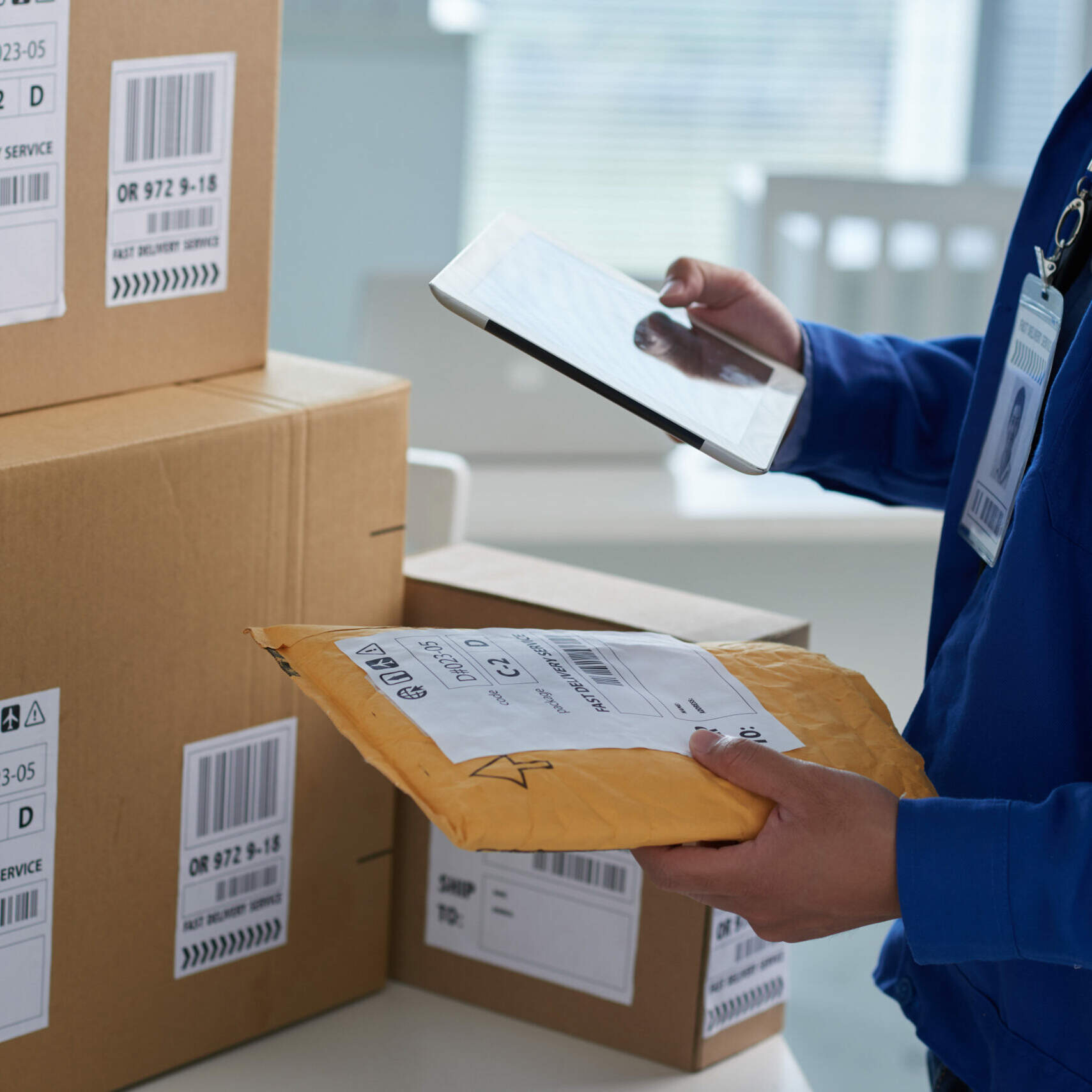 Checkig shipping info Close-up image of mail worker checking information on parcels