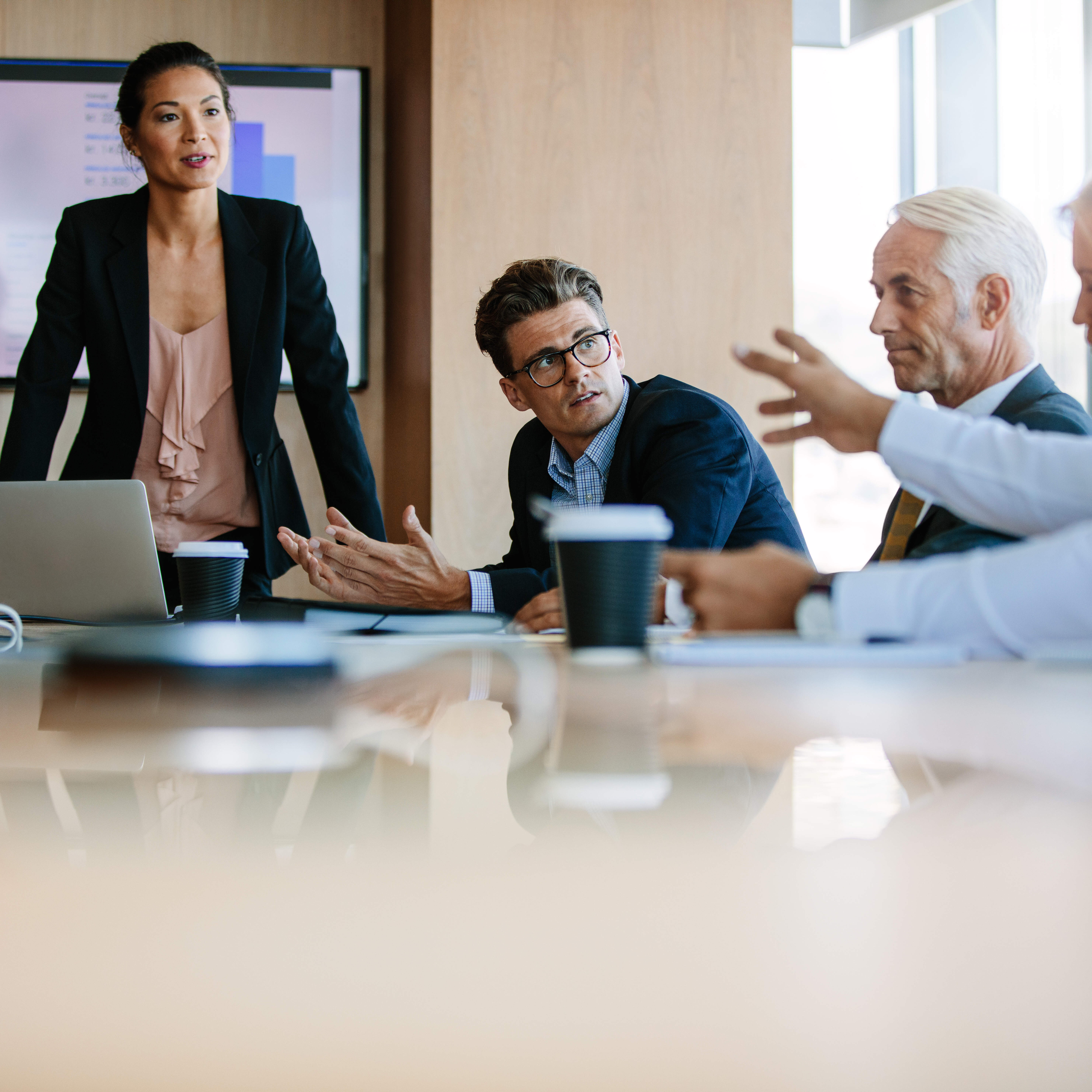Diverse business group having a meeting in boardroom Team of business people sitting together in discussion around conference table. Diverse business group having a meeting in boardroom.